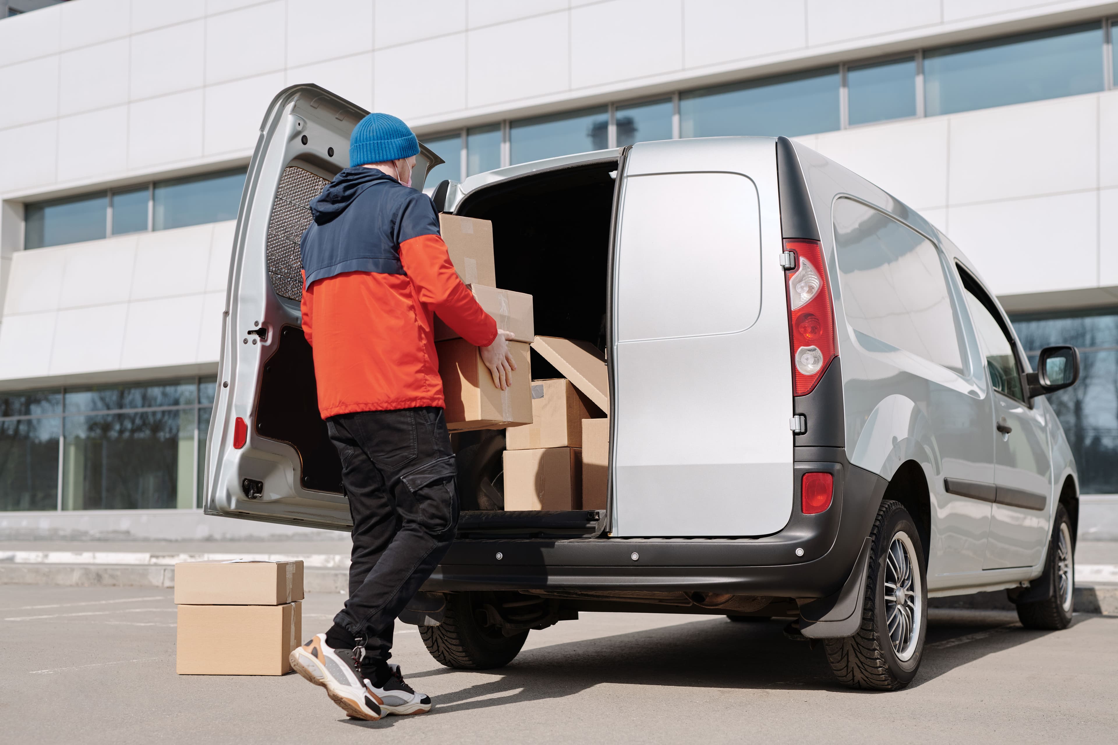 A driver loading boxes into the back of an SPS delivery van